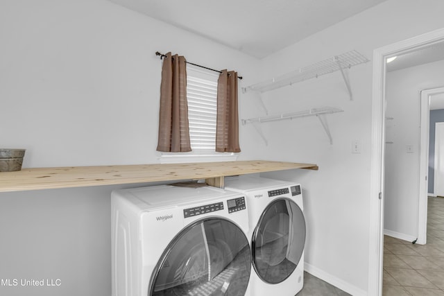 washroom featuring washer and clothes dryer, laundry area, baseboards, and light tile patterned floors