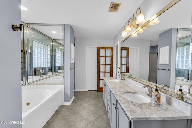 bathroom featuring tile patterned flooring, a bathtub, vanity, and a notable chandelier