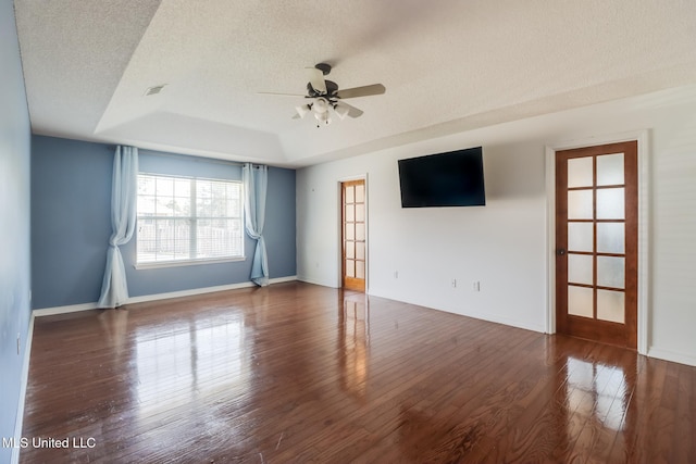 spare room featuring visible vents, a ceiling fan, a textured ceiling, wood finished floors, and baseboards