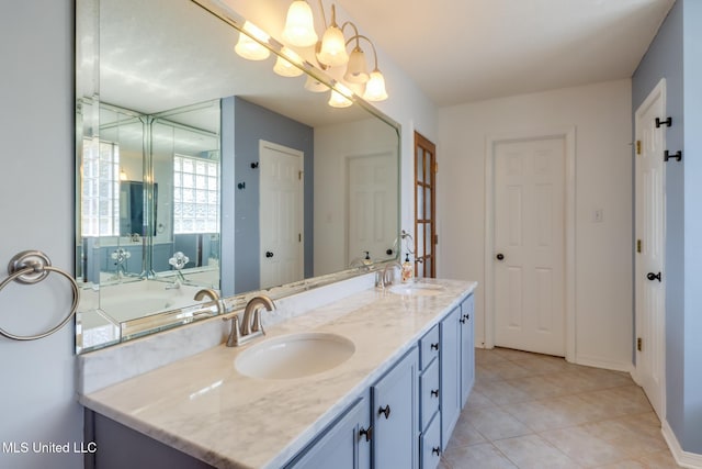 full bathroom featuring double vanity, tile patterned flooring, an inviting chandelier, and a sink