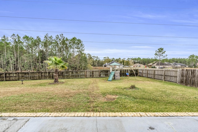 view of yard featuring a playground and a fenced backyard