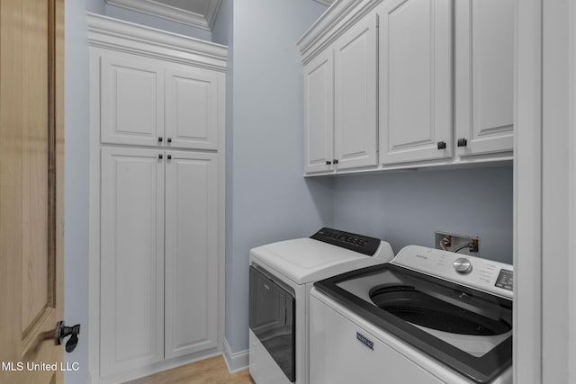 clothes washing area featuring cabinets and washer and dryer