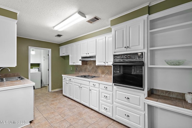 kitchen featuring oven, washer / clothes dryer, backsplash, white cabinetry, and gas stovetop