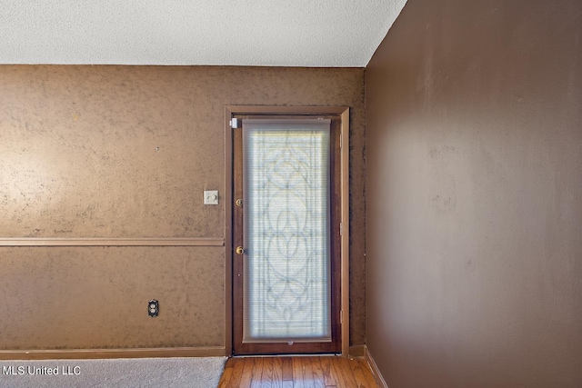 entryway with hardwood / wood-style flooring and a textured ceiling