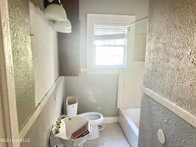 bathroom featuring toilet, shower / washtub combination, and tile patterned flooring