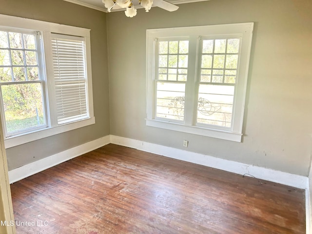 empty room with a wealth of natural light, ornamental molding, and dark hardwood / wood-style flooring