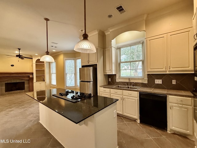 kitchen featuring black dishwasher, white gas stovetop, visible vents, freestanding refrigerator, and a sink