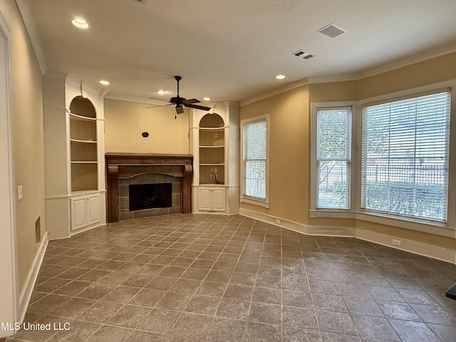 unfurnished living room featuring baseboards, visible vents, a ceiling fan, crown molding, and a fireplace