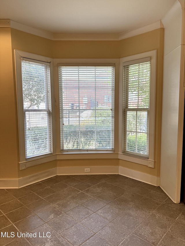 interior space featuring crown molding, granite finish floor, and baseboards