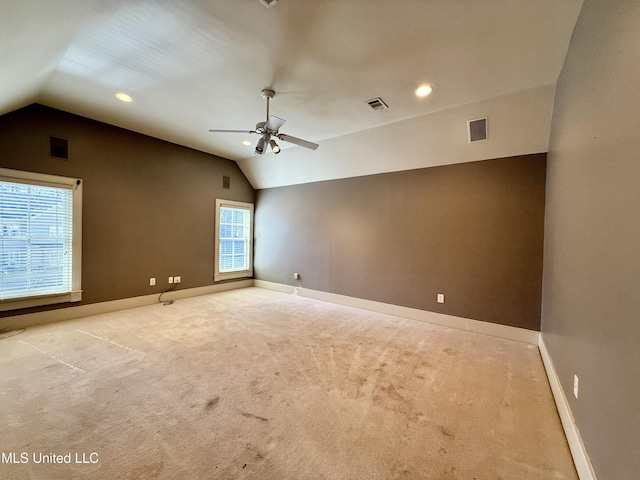 spare room with lofted ceiling, baseboards, and visible vents