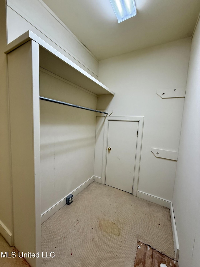 laundry area featuring baseboards and light colored carpet