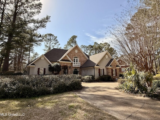 view of front of property featuring brick siding and stucco siding