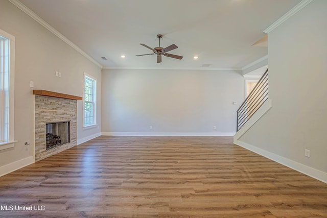 unfurnished living room featuring crown molding, a stone fireplace, light wood-type flooring, and ceiling fan