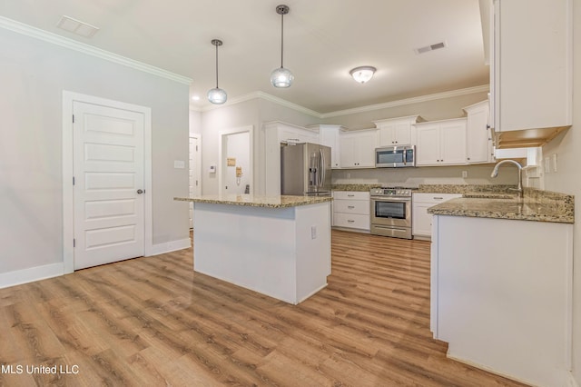 5640 Drew Glazer Dr, Olive Branch, MS 38654 - kitchen featuring stainless steel appliances, a sink, light wood finished floors, ornamental molding, and white cabinets