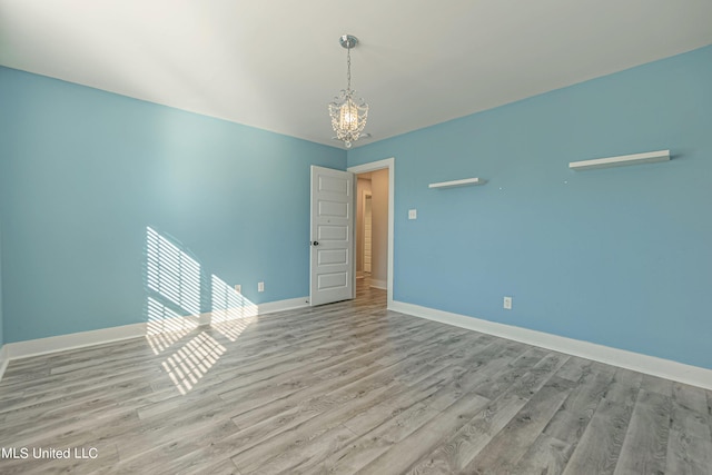 5640 Drew Glazer Dr, Olive Branch, MS 38654 - unfurnished room with a chandelier, wood finished floors, and baseboards