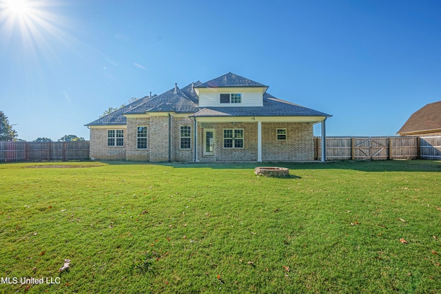 rear view of property featuring a patio area, an outdoor fire pit, and a lawn