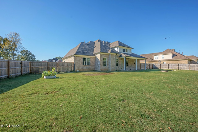 back of property with a patio area and a yard