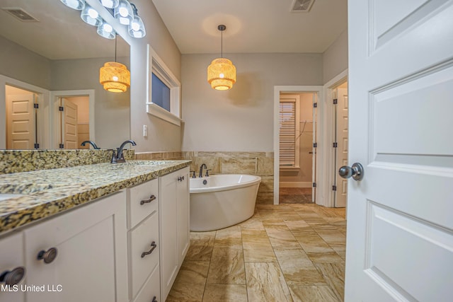 bathroom featuring a bathtub, tile walls, and vanity