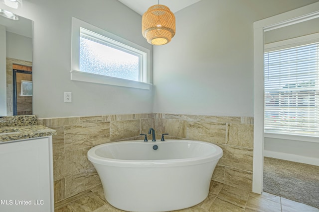 5640 Drew Glazer Dr, Olive Branch, MS 38654 - full bath featuring tile walls, a soaking tub, vanity, a wainscoted wall, and tile patterned floors