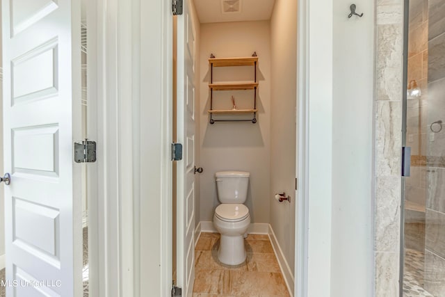 bathroom with a shower with door and toilet