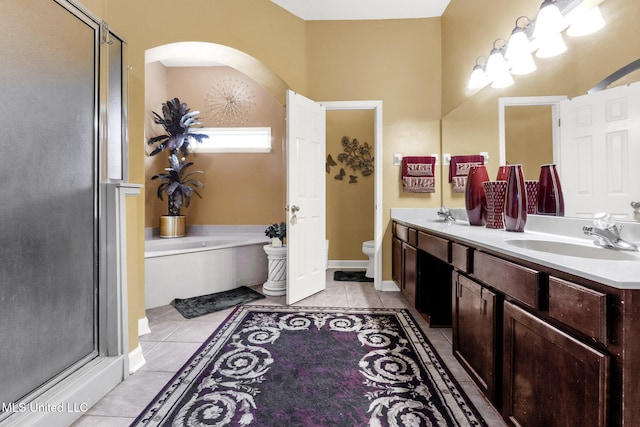 bathroom featuring tile patterned floors, toilet, a shower stall, a bath, and double vanity
