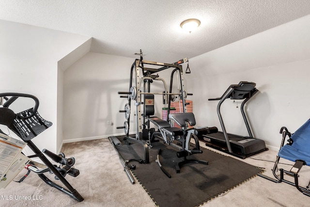 workout room featuring carpet floors, a textured ceiling, and baseboards