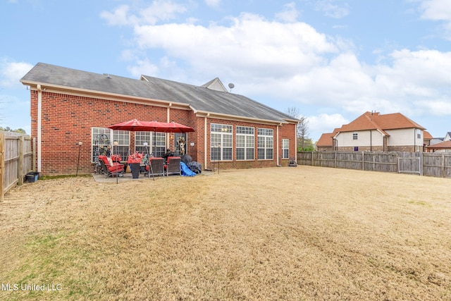 rear view of property featuring brick siding, a patio area, and a shingled roof