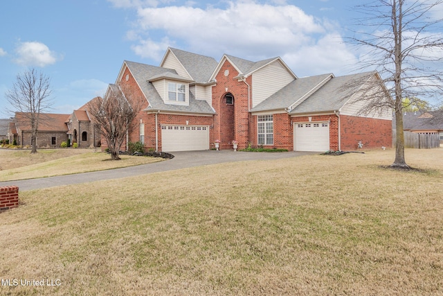 traditional-style home with brick siding, asphalt driveway, a front yard, and roof with shingles