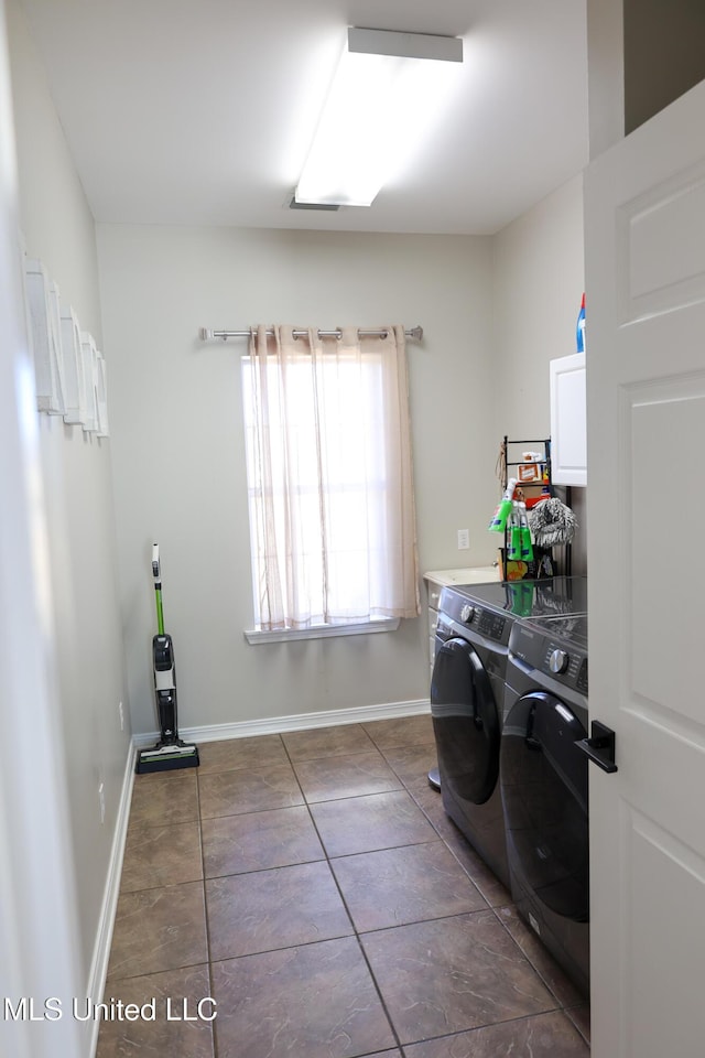 laundry room with cabinets, dark tile patterned flooring, and washer and clothes dryer