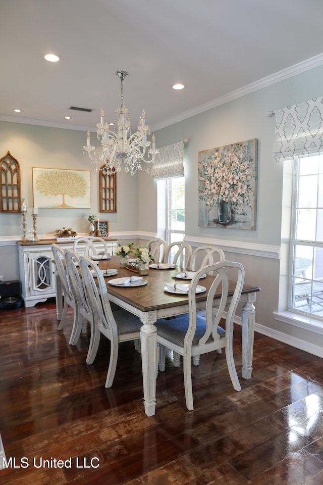 dining area with dark hardwood / wood-style flooring, crown molding, and a notable chandelier