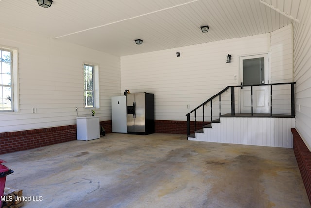 garage featuring stainless steel fridge with ice dispenser