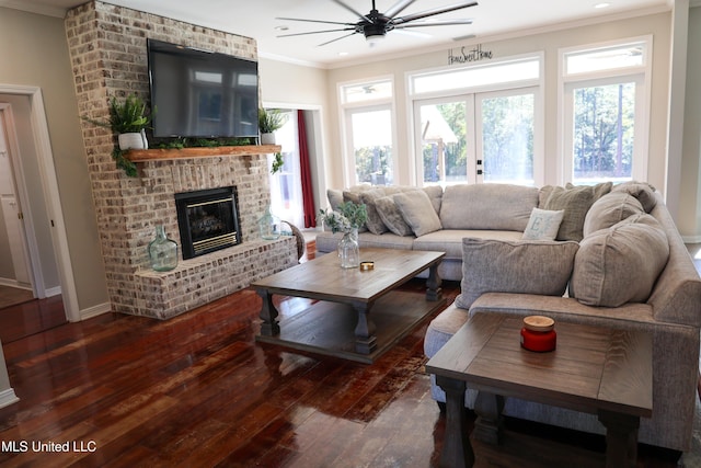 living room with ceiling fan, french doors, a brick fireplace, dark hardwood / wood-style flooring, and ornamental molding