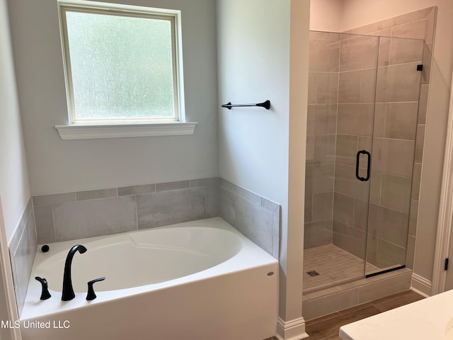 bathroom with a shower stall and a garden tub