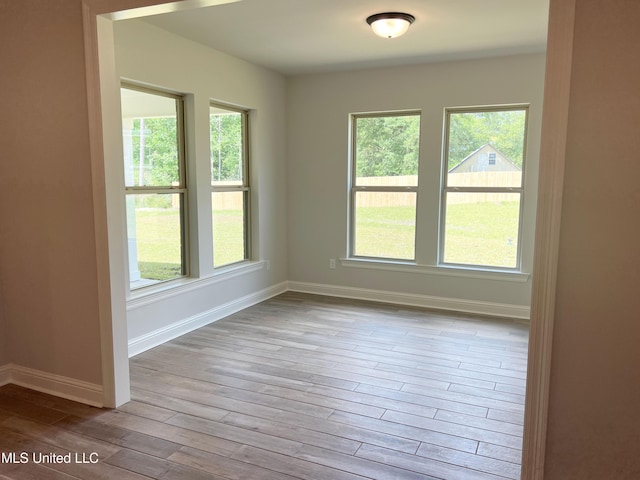 unfurnished room featuring baseboards and hardwood / wood-style flooring
