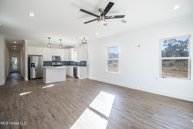 kitchen with a center island, dark wood-type flooring, white cabinets, decorative light fixtures, and stainless steel appliances