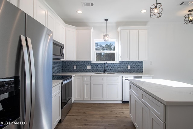 kitchen with white cabinets, decorative light fixtures, and stainless steel appliances