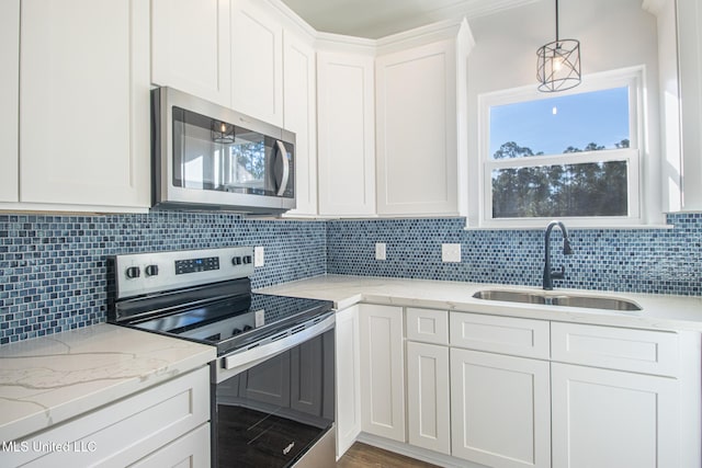 kitchen with sink, hanging light fixtures, stainless steel appliances, tasteful backsplash, and white cabinets