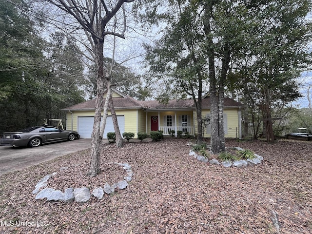 ranch-style home featuring a garage, covered porch, and concrete driveway