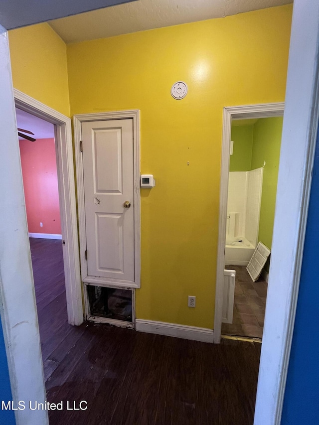 hallway featuring dark wood-style floors and baseboards