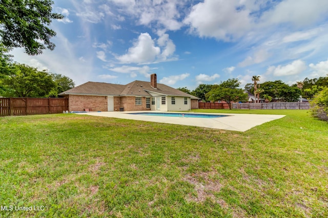 back of house featuring a fenced backyard, a patio area, a chimney, and a yard