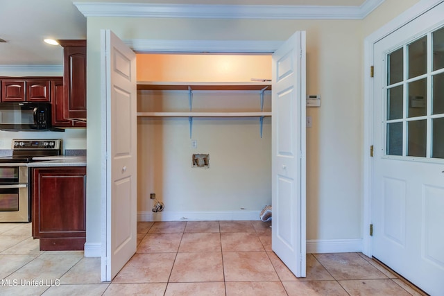 laundry room featuring laundry area, washer hookup, light tile patterned floors, and crown molding