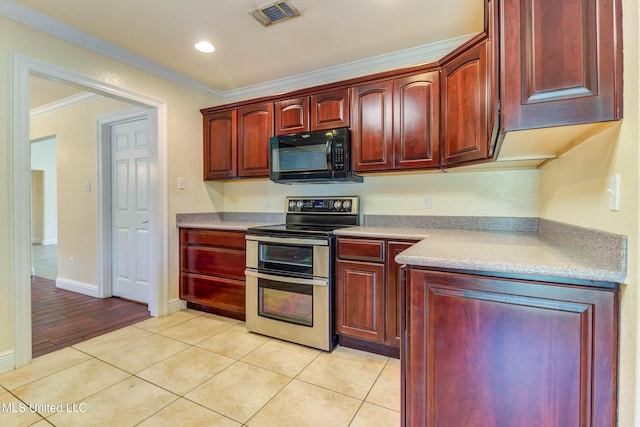 kitchen with ornamental molding, visible vents, black microwave, range with two ovens, and reddish brown cabinets