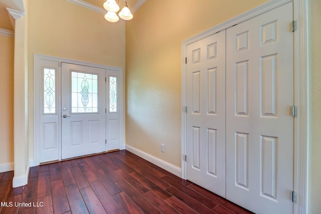foyer entrance featuring ornamental molding, baseboards, and dark wood finished floors