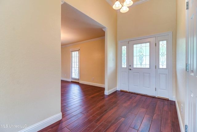 foyer featuring crown molding, baseboards, and dark wood-style floors
