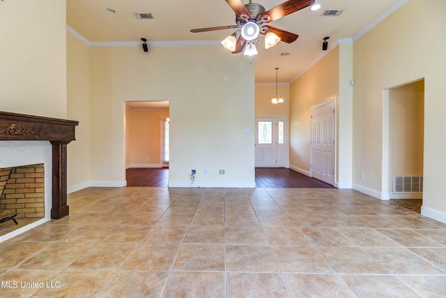 unfurnished living room featuring ceiling fan, visible vents, a towering ceiling, and ornamental molding