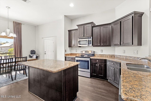 kitchen featuring a notable chandelier, a kitchen island, sink, stainless steel appliances, and dark hardwood / wood-style flooring