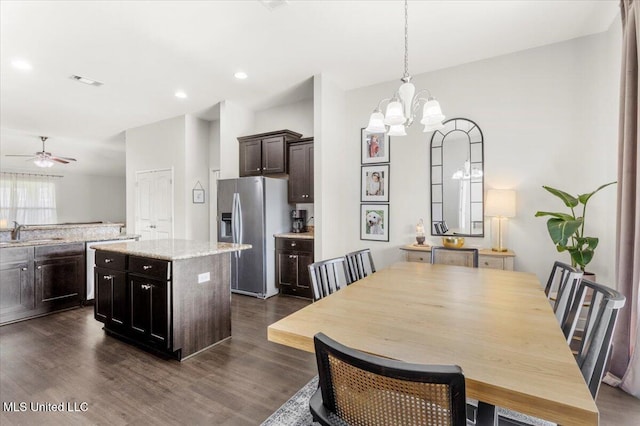 dining room featuring dark wood-type flooring, ceiling fan with notable chandelier, and sink