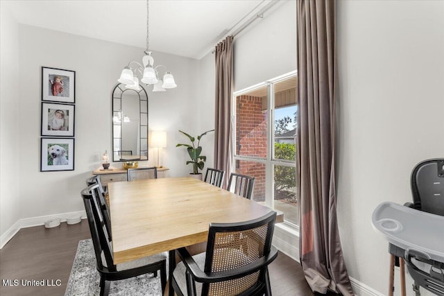 dining space featuring dark wood-type flooring and an inviting chandelier