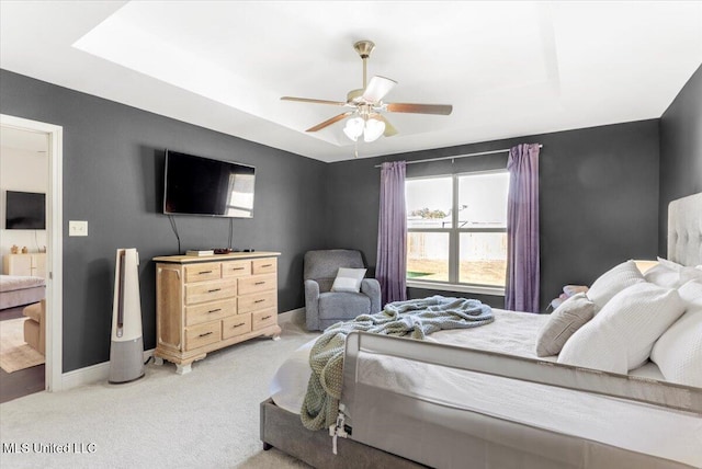 bedroom with ceiling fan, carpet, and a raised ceiling