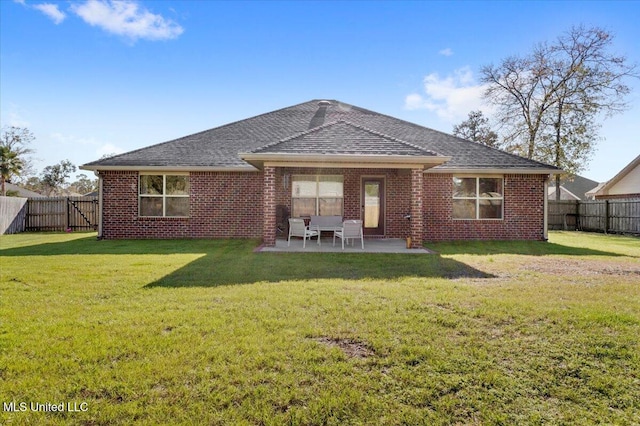 back of house featuring a lawn and a patio